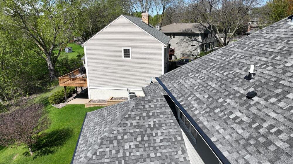 New gutters along a shingle roof seen from above