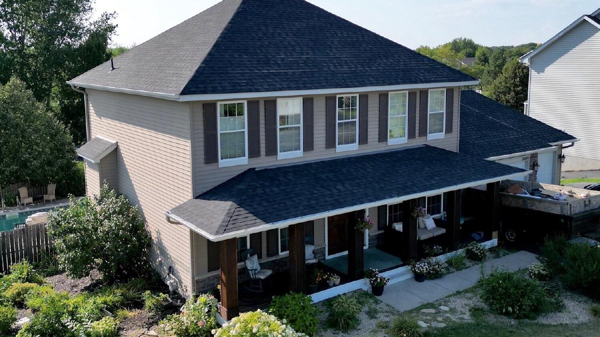 New dark asphalt shingle roof on a two-story home with a covered porch
