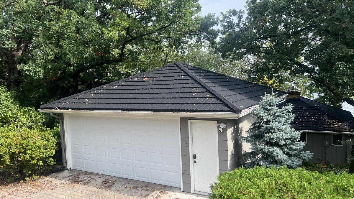 Metal roof installation on a residential home with new siding and seamless gutters. | Omega Exteriors