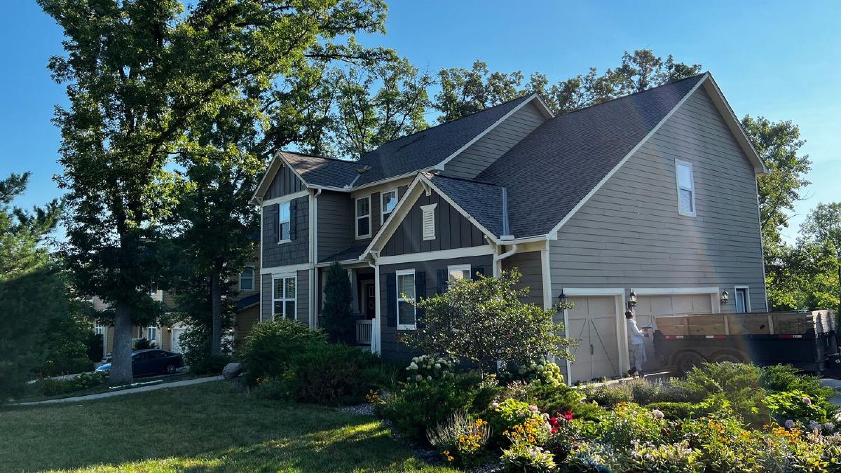 Two-story home with new gray lap and board and batten siding