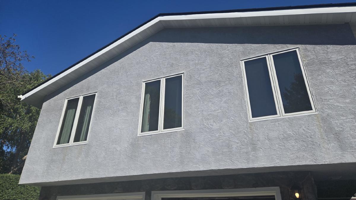 Replacement windows on a gray stucco home