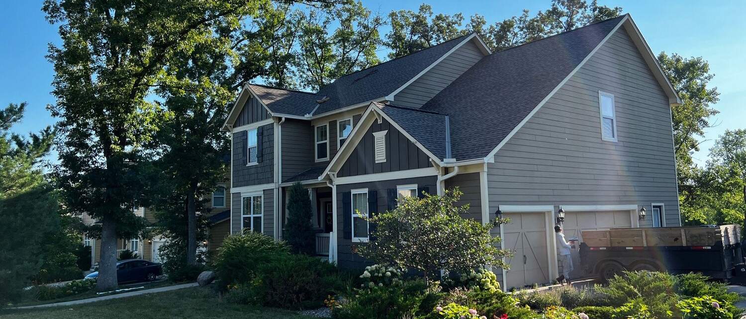 Two-story home with new gray lap and board and batten siding
