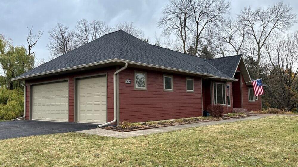 Red siding on a ranch home with a two-car garage