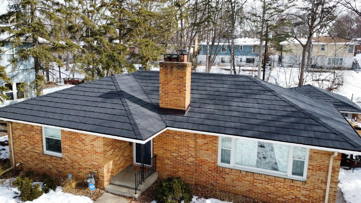 Brick ranch home with new gutters and a dark roof