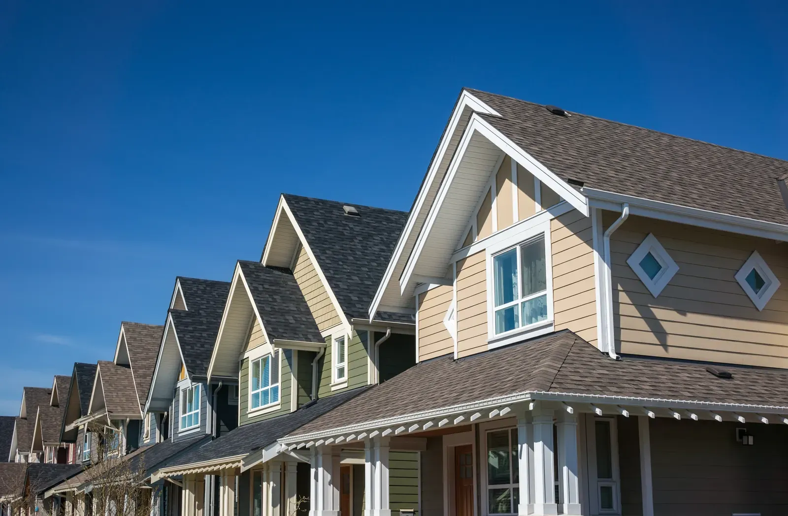 Image of a multi-family home showcasing new asphalt roofing and vinyl siding replacements. | Omega Exteriors