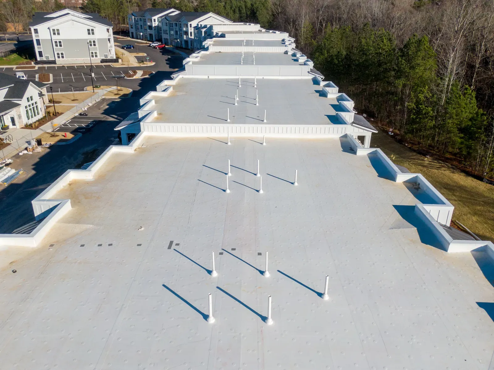 Dynamic image of a commercial roof installation using EPDM material, showcasing a hero-approved process. | Omega Exterio