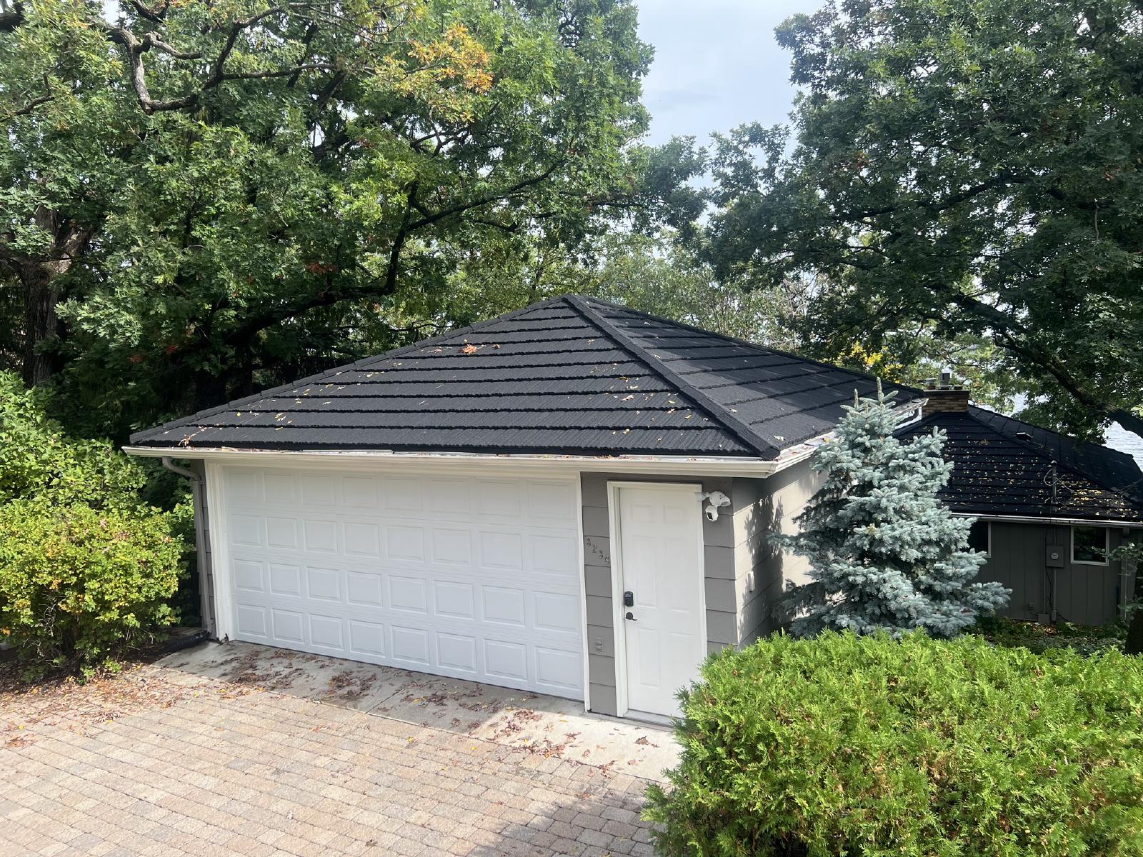 Metal roof installation on a residential home with new siding and seamless gutters. | Omega Exteriors