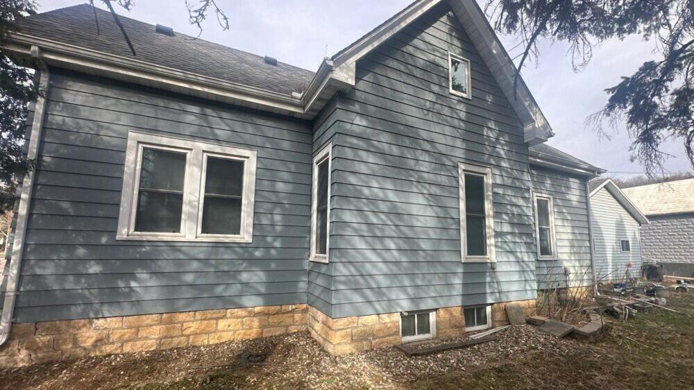 Blue fiber cement lap siding on a home with white-trimmed windows