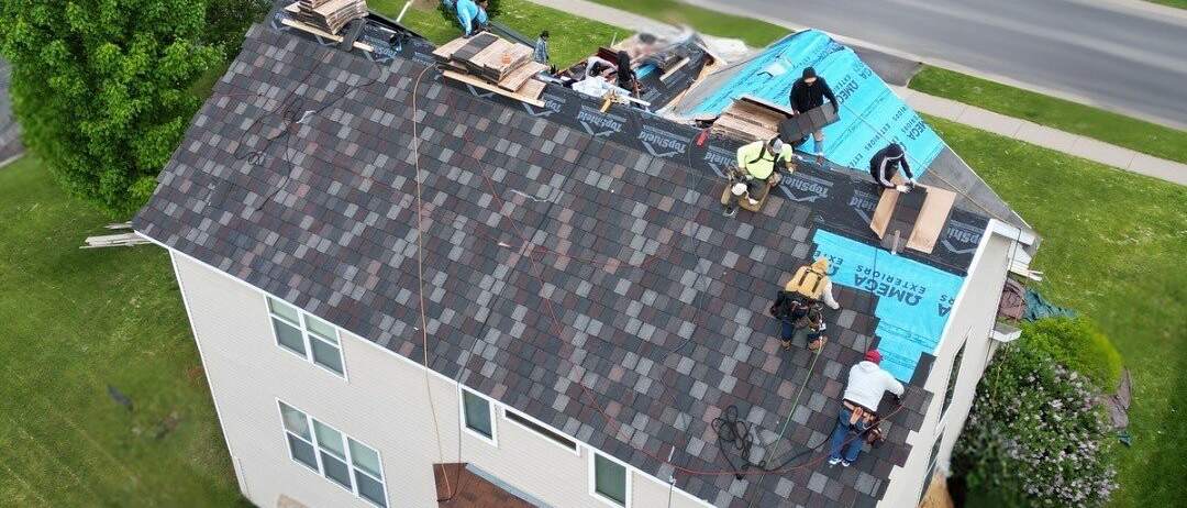 Omega Exteriors crew installing a new shingle roof