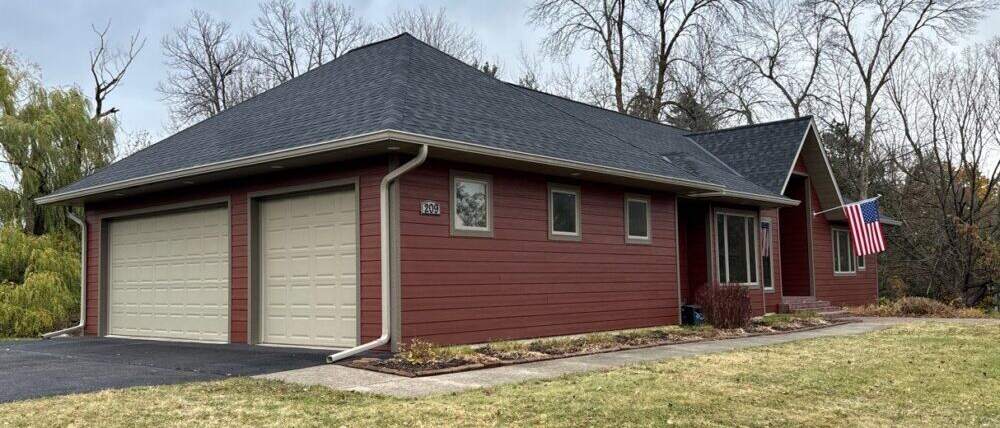 Red siding on a ranch home with a two-car garage