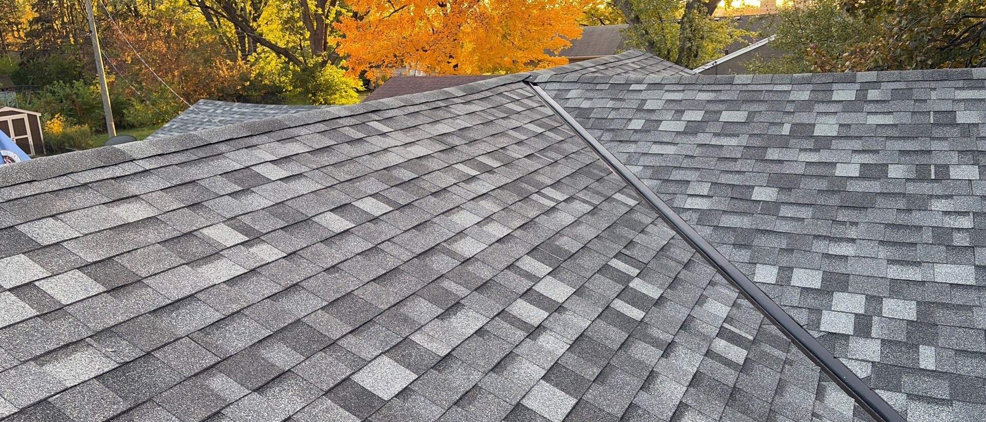 Repaired gray asphalt shingles along a roof ridge