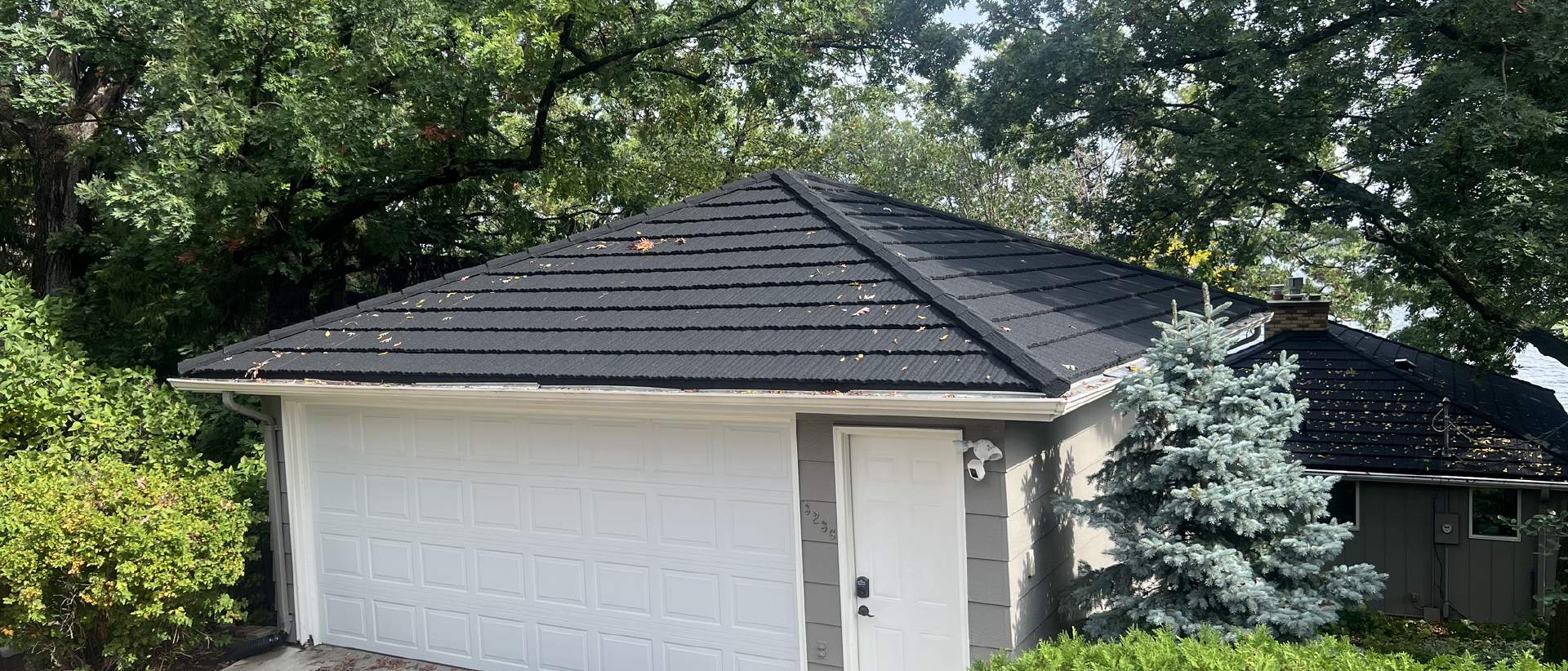 Metal roof installation on a residential home with new siding and seamless gutters. | Omega Exteriors