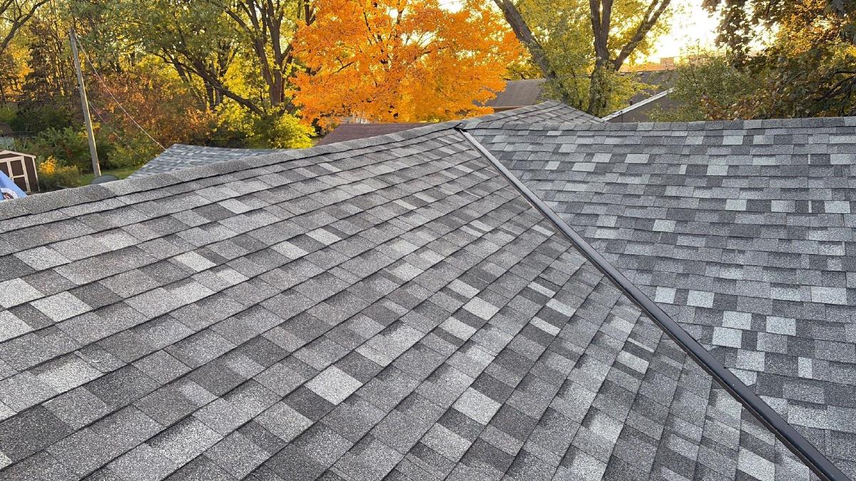 Repaired gray asphalt shingles along a roof ridge