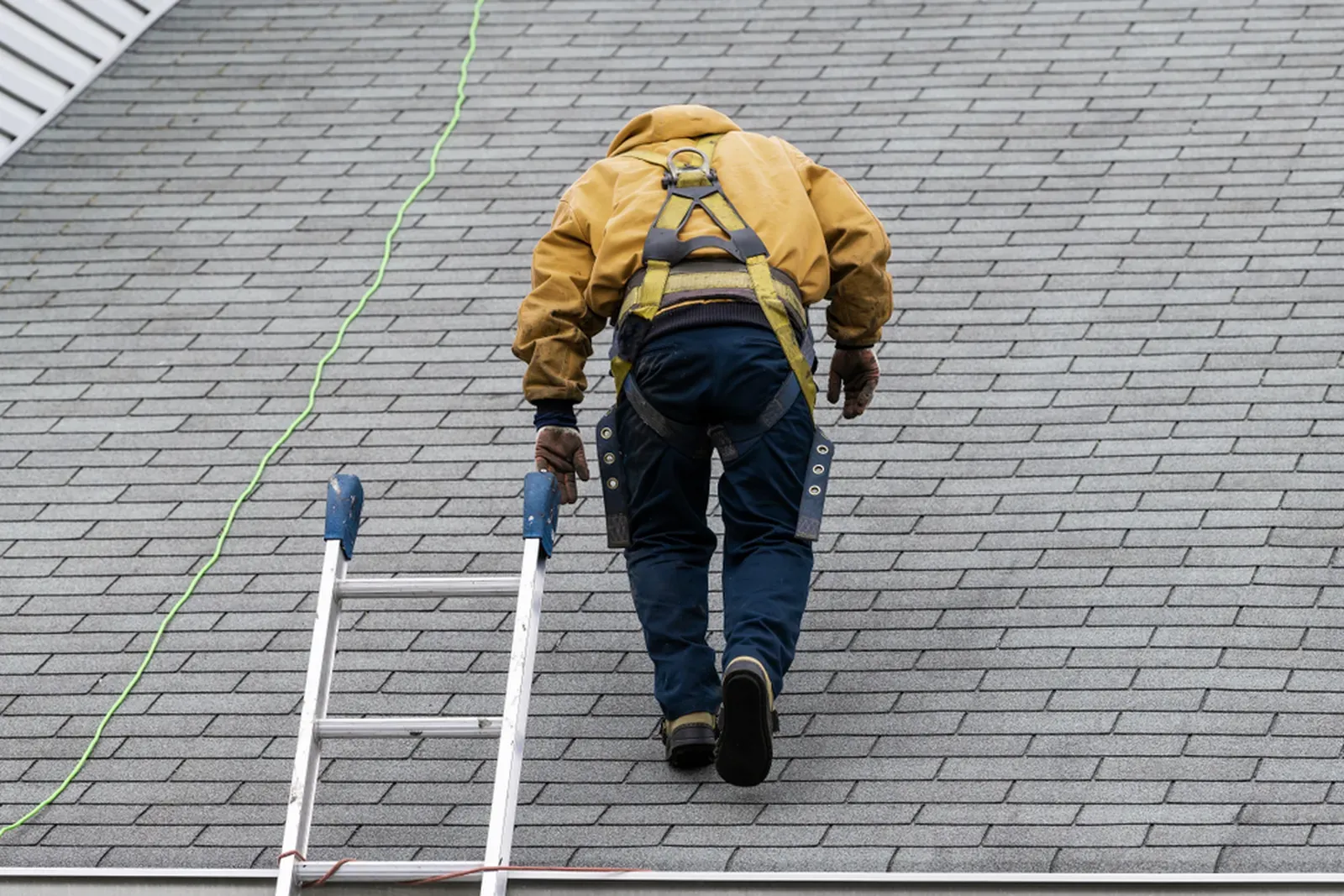 Residential asphalt roof repair in progress on a sunny day. | Omega Exteriors