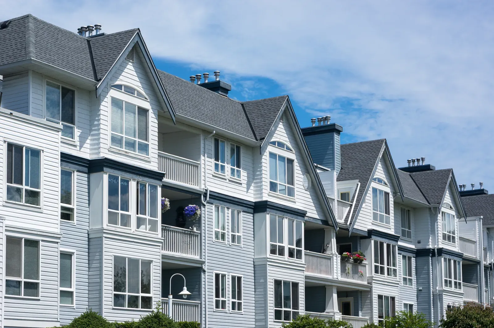 "Image of a multi-family home with new asphalt roof and vinyl siding installation." | Omega Exteriors