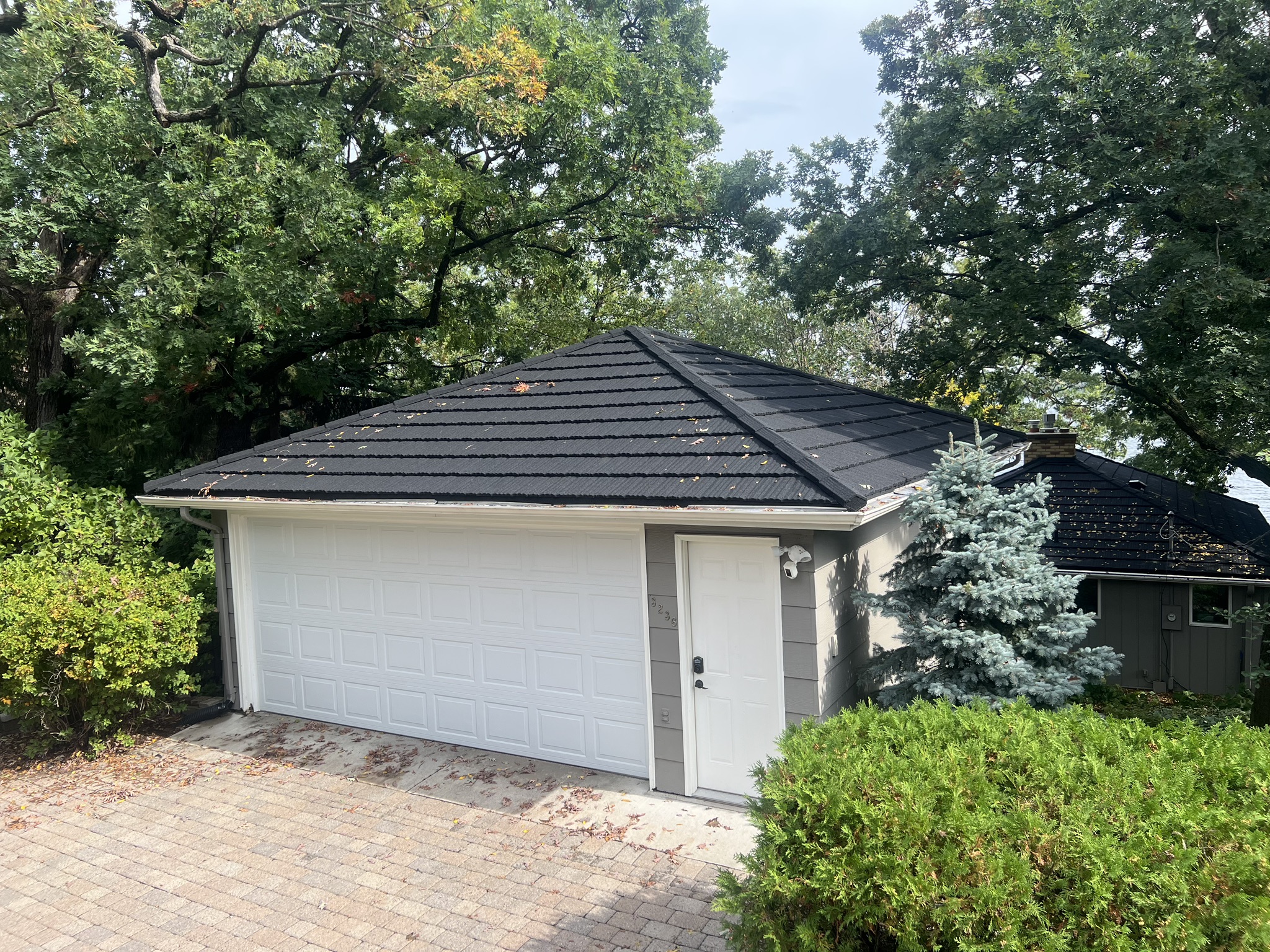 Metal roof installation on a residential home with new siding and seamless gutters. | Omega Exteriors
